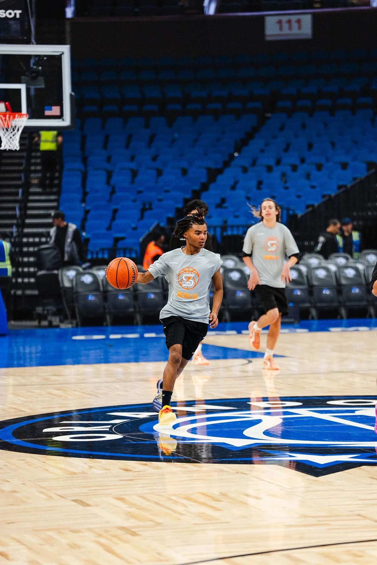 Athletes sprinting through a ball-handling drill at center court