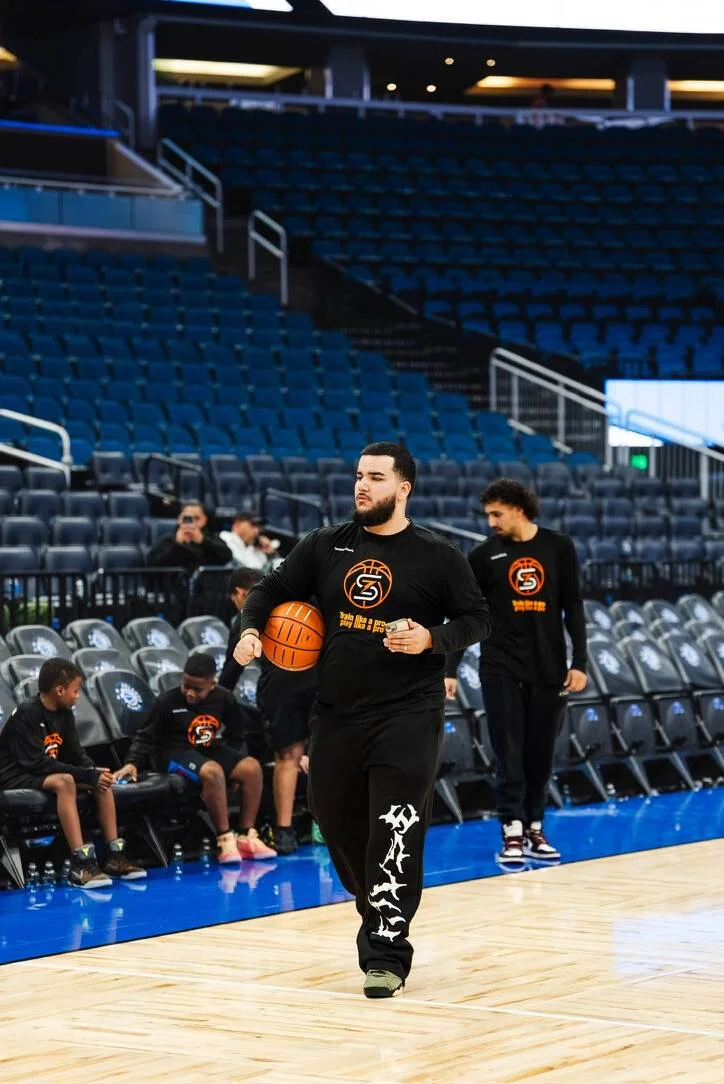 Jesus 'Coach Zeus' Nino, founder of Zeus Skills Training, holding a basketball on an NBA court