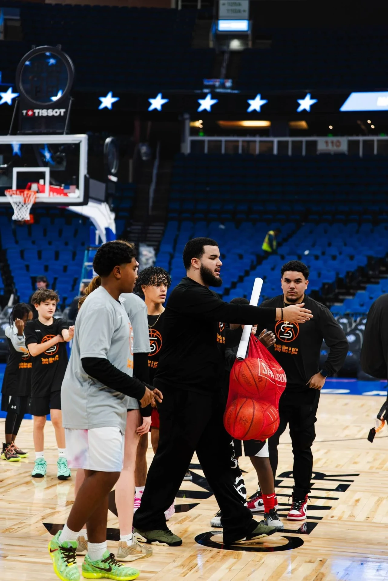 Coach directing young players during arena warm-ups