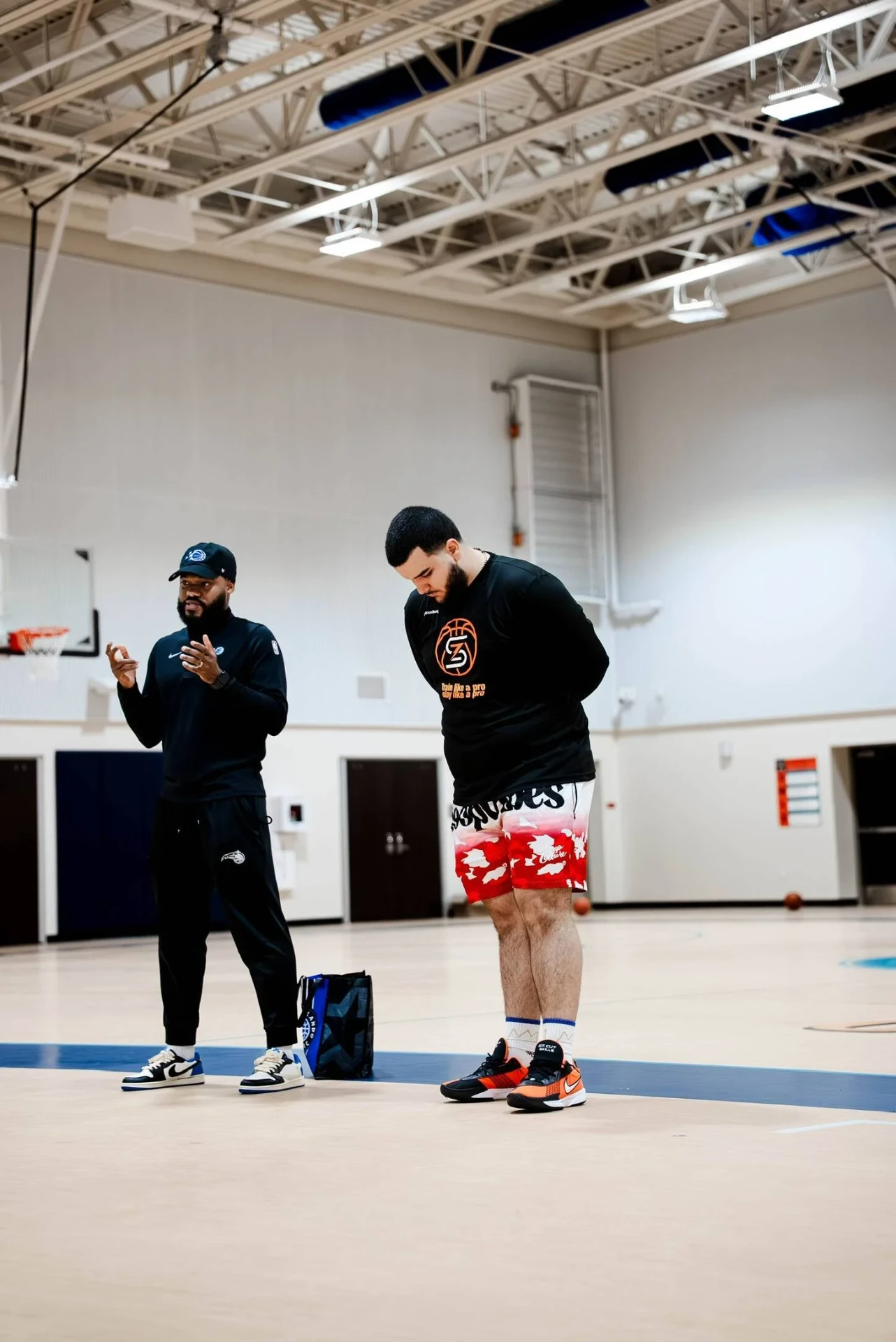 Zeus Skills coach talking with an NBA staff coach on the practice court