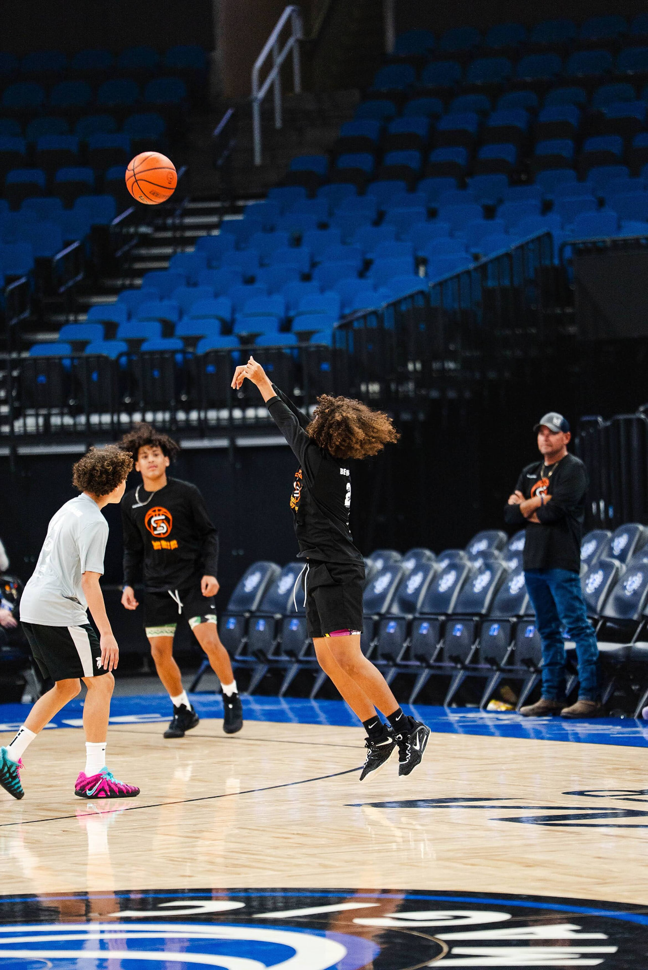 Coach instructing a full group of players at center court