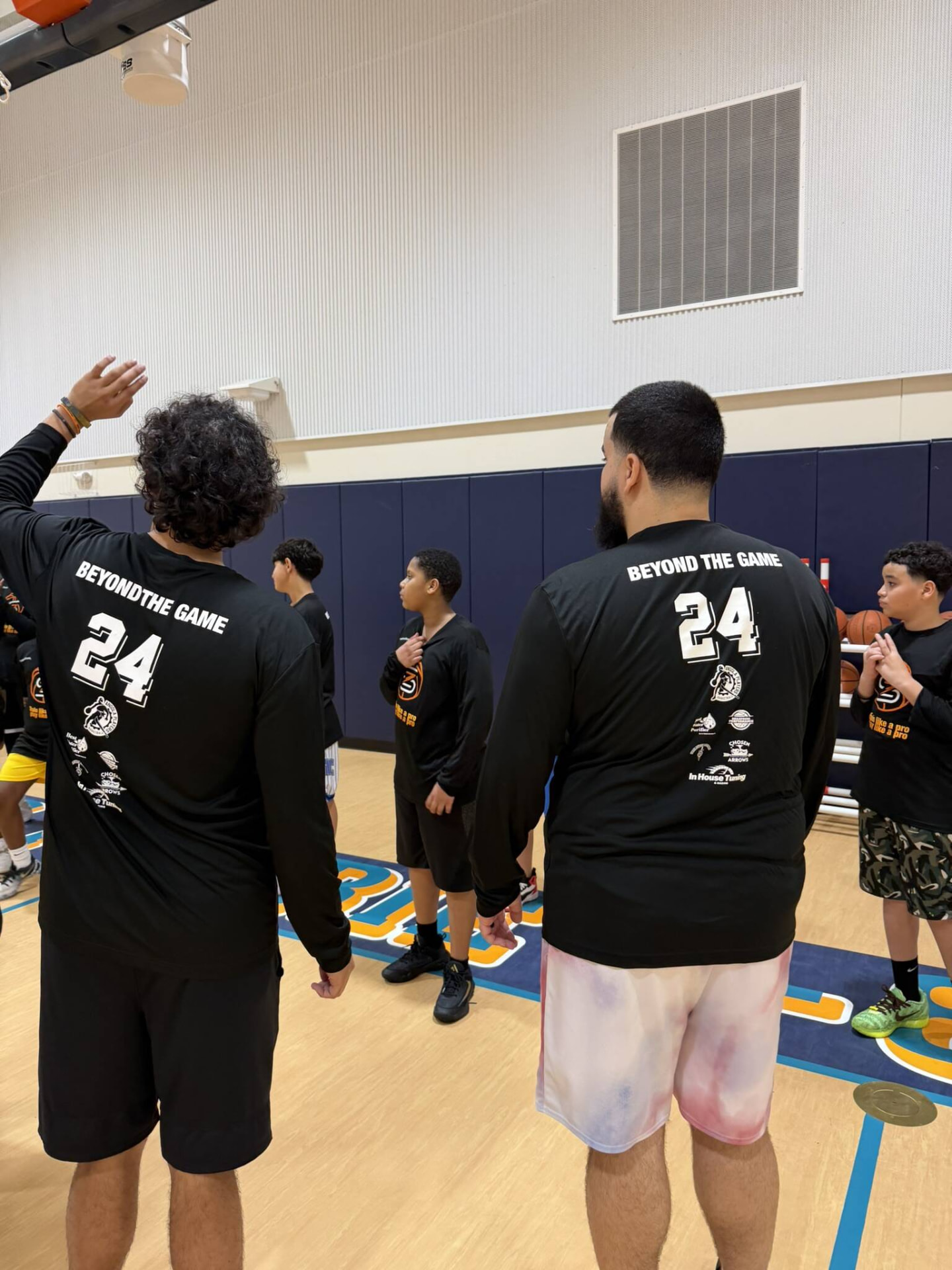 Players in Beyond The Game shirts listening during a gym session